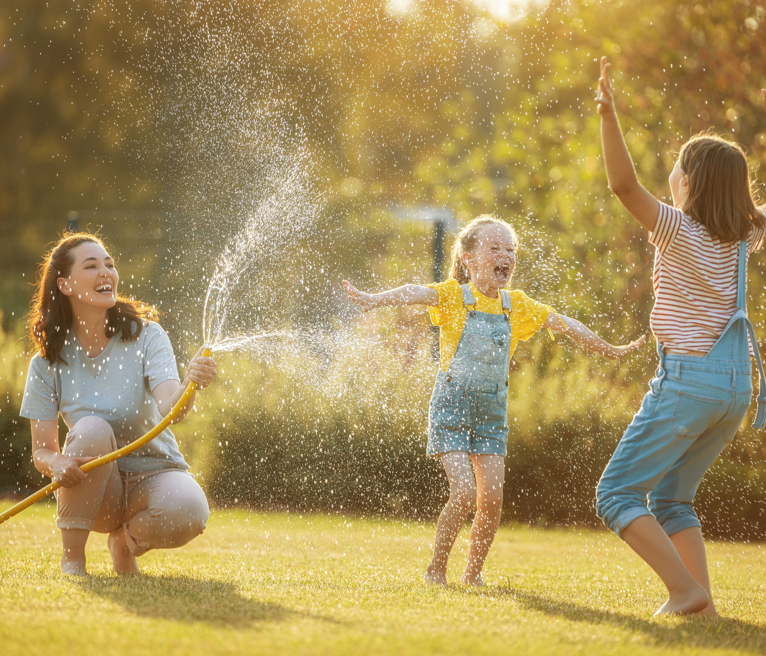 kids playing with sprinkler in yard
